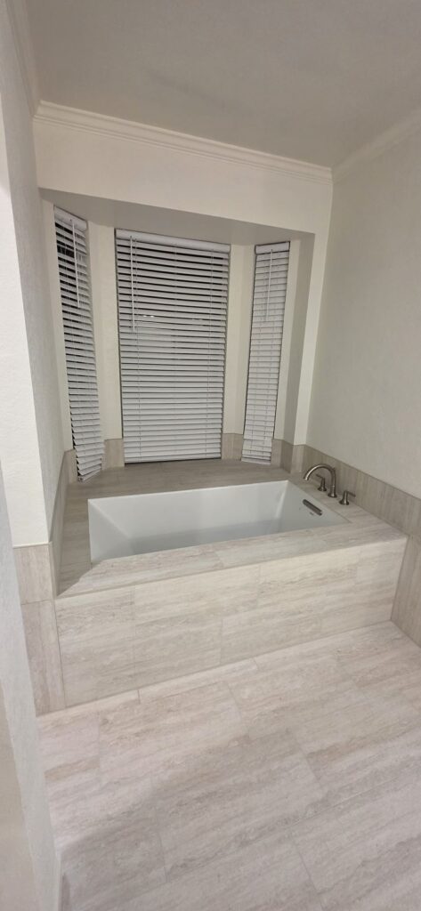 Tiled soaking tub by Fixora in Plano, TX